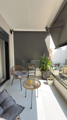 a balcony with two chairs and a table at Andria's Apartment in Athens