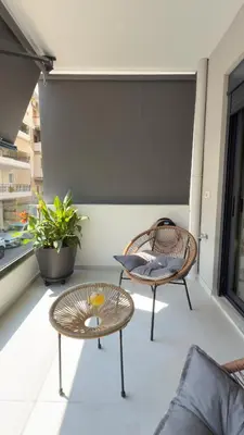 a balcony with a table and chairs on a building at Andria's Apartment in Athens