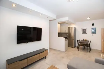 a living room with a flat screen tv on a wall at Ilissos Harmony Apartment in Piraeus