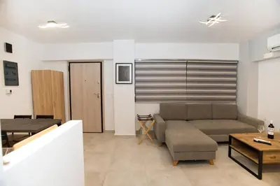 a living room with a couch and a table at Ilissos Harmony Apartment in Piraeus