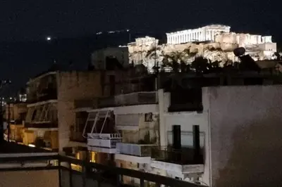 a view of a building at night at Acropolis view, in the center of Athens! 4pl in Athens