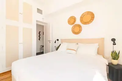 a bedroom with a large white bed with white walls at Acropolis view, in the center of Athens! 4pl in Athens