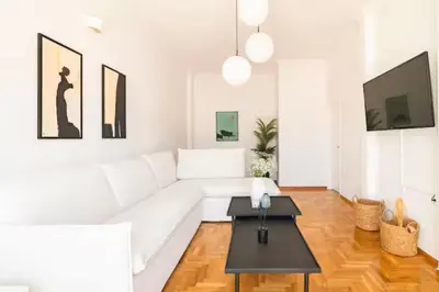 a white living room with a white couch and a table at Acropolis view, in the center of Athens! 4pl in Athens