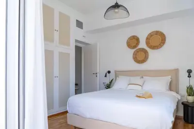 a white bedroom with a white bed and a window at Acropolis view, in the center of Athens! 4pl in Athens