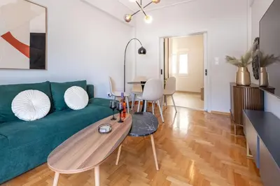 a living room with a green couch and a table at Boutique Athens Flat in Koukaki, Walk to Acropolis in Athens