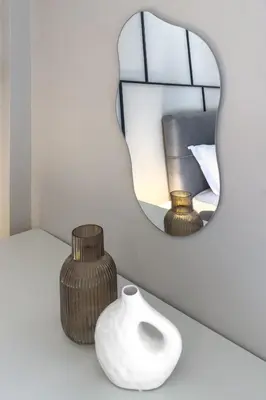 a mirror and a white vase on a white table at Boutique Athens Flat in Koukaki, Walk to Acropolis in Athens