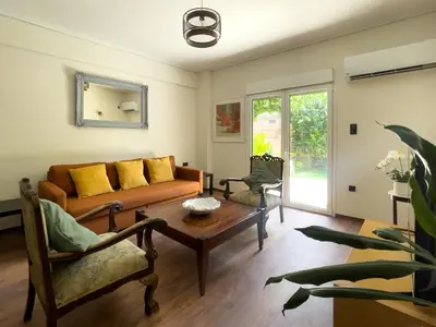 a living room with a couch and a table at Alegria's 2BR Garden Apartment in Athens