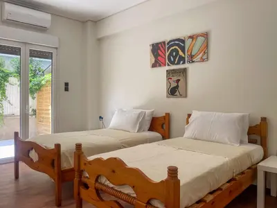 a bedroom with two beds and a window at Alegria's 2BR Garden Apartment in Athens