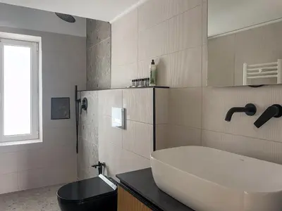 a bathroom with a tub and a toilet and a sink at Alegria's 2BR Garden Apartment in Athens