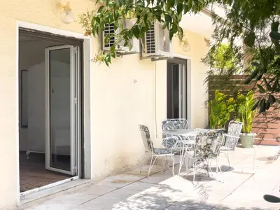 a patio with a table and chairs in front of a building at Alegria's 2BR Garden Apartment in Athens
