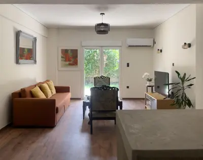 a living room with a couch and a chair at Alegria's 2BR Garden Apartment in Athens