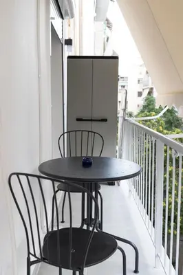 a black table and chairs on a balcony at Pagrati Art & Love in Athens