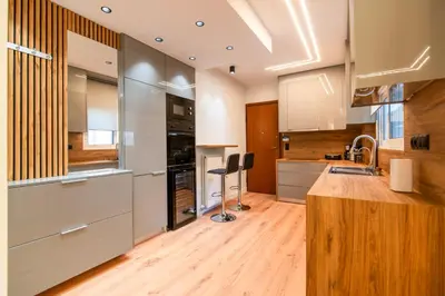 a kitchen with stainless steel appliances and wooden floors at Cozy 2-Bedroom by Flisvos Marina in Athens