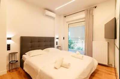 a bedroom with a large white bed and a window at Cozy 2-Bedroom by Flisvos Marina in Athens