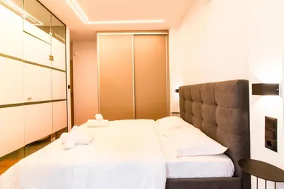 a bedroom with a large white bed and a mirror at Cozy 2-Bedroom by Flisvos Marina in Athens