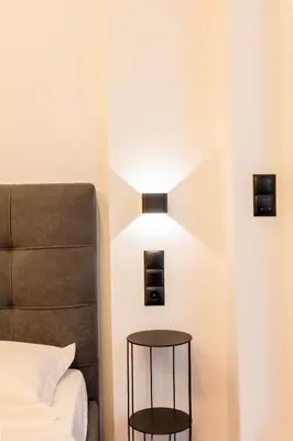 a bedroom with a bed and a lamp on the wall at Cozy 2-Bedroom by Flisvos Marina in Athens