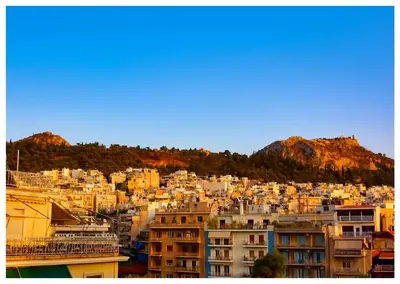 a view of a city with buildings and mountains at Panathenea Rooftop Apartment with Stunning View of Lycabettus in Athens