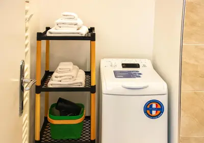 a small laundry room with a washer and dryer at Panathenea Rooftop Apartment with Stunning View of Lycabettus in Athens