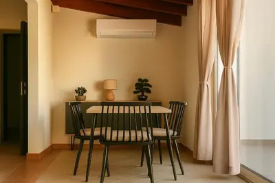 a dining room table with two chairs and a plant at Panathenea Rooftop Apartment with Stunning View of Lycabettus in Athens