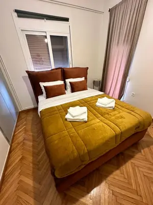 a bedroom with a large bed with two towels on it at Shoni home in Piraeus