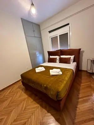 a bedroom with a large bed with two towels on it at Shoni home in Piraeus