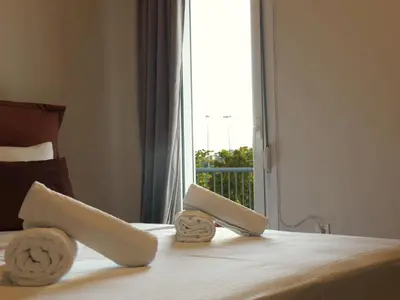 a bedroom with a bed with towels on it with a window at Shoni home in Piraeus