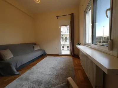 a living room with a couch and a window at Shoni home in Piraeus