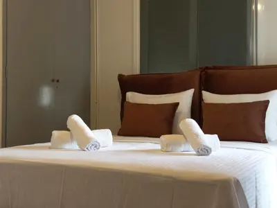 a bed with three pillows on top of it at Shoni home in Piraeus