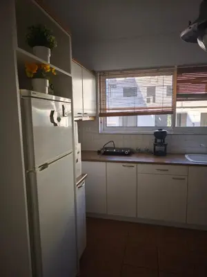 a kitchen with white cabinets and a white refrigerator at The Acropolis Athens Experience in Athens