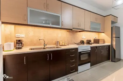 a kitchen with wooden cabinets and a sink at Emeralds - Premium & Modern Stay in Egaleo-Athens in Athens