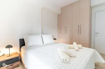 a bedroom with a white bed with towels on it at Emeralds - Premium & Modern Stay in Egaleo-Athens in Athens