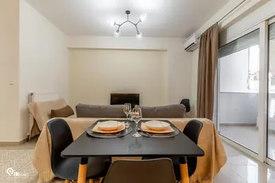 a dining room and living room with a table and chairs at Emeralds - Premium & Modern Stay in Egaleo-Athens in Athens
