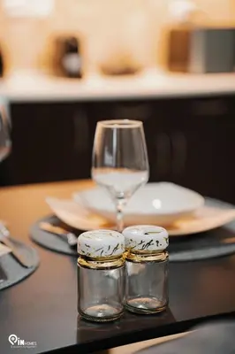 a table with a wine glass and rings on it at Emeralds - Premium & Modern Stay in Egaleo-Athens in Athens