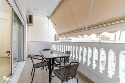 a table and chairs on the balcony of a building at Emeralds - Premium & Modern Stay in Egaleo-Athens in Athens