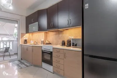 a kitchen with black cabinets and a stainless steel refrigerator at Rubies - Premium And Comfy Stay in Egaleo-Athens in Athens
