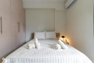 a white bedroom with a large bed with white pillows at Rubies - Premium And Comfy Stay in Egaleo-Athens in Athens