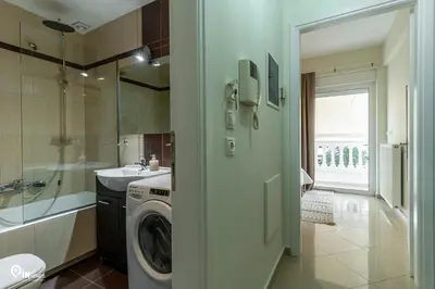 a bathroom with a washing machine and a sink at Rubies - Premium And Comfy Stay in Egaleo-Athens in Athens