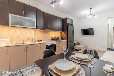 a kitchen with a table and chairs and a kitchen with a kitchen at Rubies - Premium And Comfy Stay in Egaleo-Athens in Athens