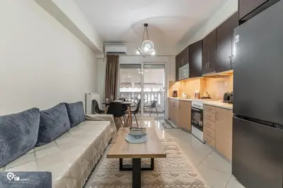 a living room with a couch and a table in a kitchen at Rubies - Premium And Comfy Stay in Egaleo-Athens in Athens