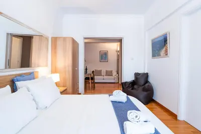 a bedroom with a white bed and a living room at Syntagma square, 60sqm Fancy apartment in Athens