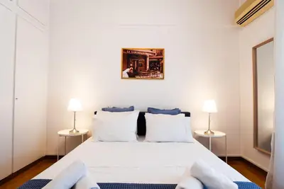 a bedroom with a large white bed with two lamps at Syntagma square, 60sqm Fancy apartment in Athens