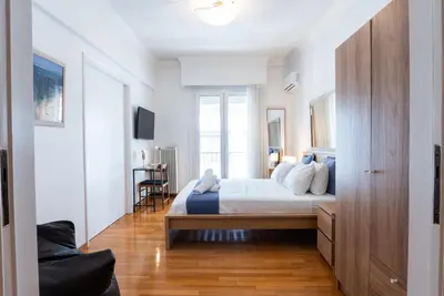 a white bedroom with a bed and a window at Syntagma square, 60sqm Fancy apartment in Athens