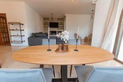 a wooden table with flowers in a living room at The Hidden Muse 3BD Free Parking in Athens