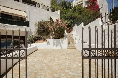 a fence in front of a building with flowers at The Hidden Muse 3BD Free Parking in Athens