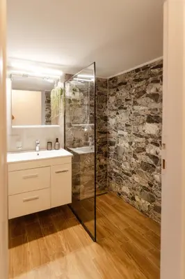 a bathroom with a sink and a stone wall at The Hidden Muse 3BD Free Parking in Athens