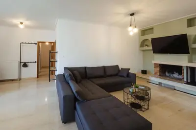 a living room with a couch and a tv at The Hidden Muse 3BD Free Parking in Athens