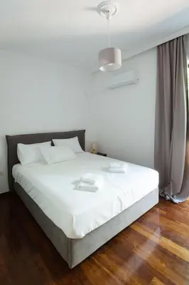 a bedroom with a white bed with white sheets at The Hidden Muse 3BD Free Parking in Athens