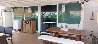 a patio with a wooden table and some windows at Rooftop bliss in Athens