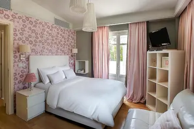 a bedroom with a white bed and pink wallpaper at GT Dreams Villa - Luxury Villa near the Athenian Riviera in Vari