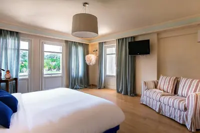 a bedroom with a large bed and a couch at GT Dreams Villa - Luxury Villa near the Athenian Riviera in Vari